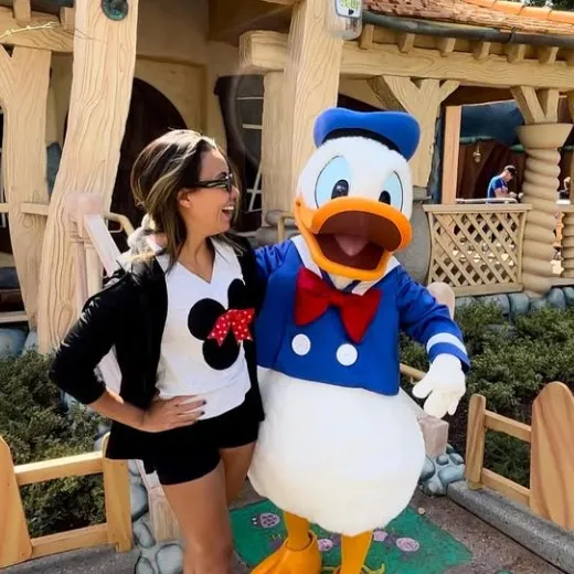 Gabriela sorrindo ao lado do Pato Donald