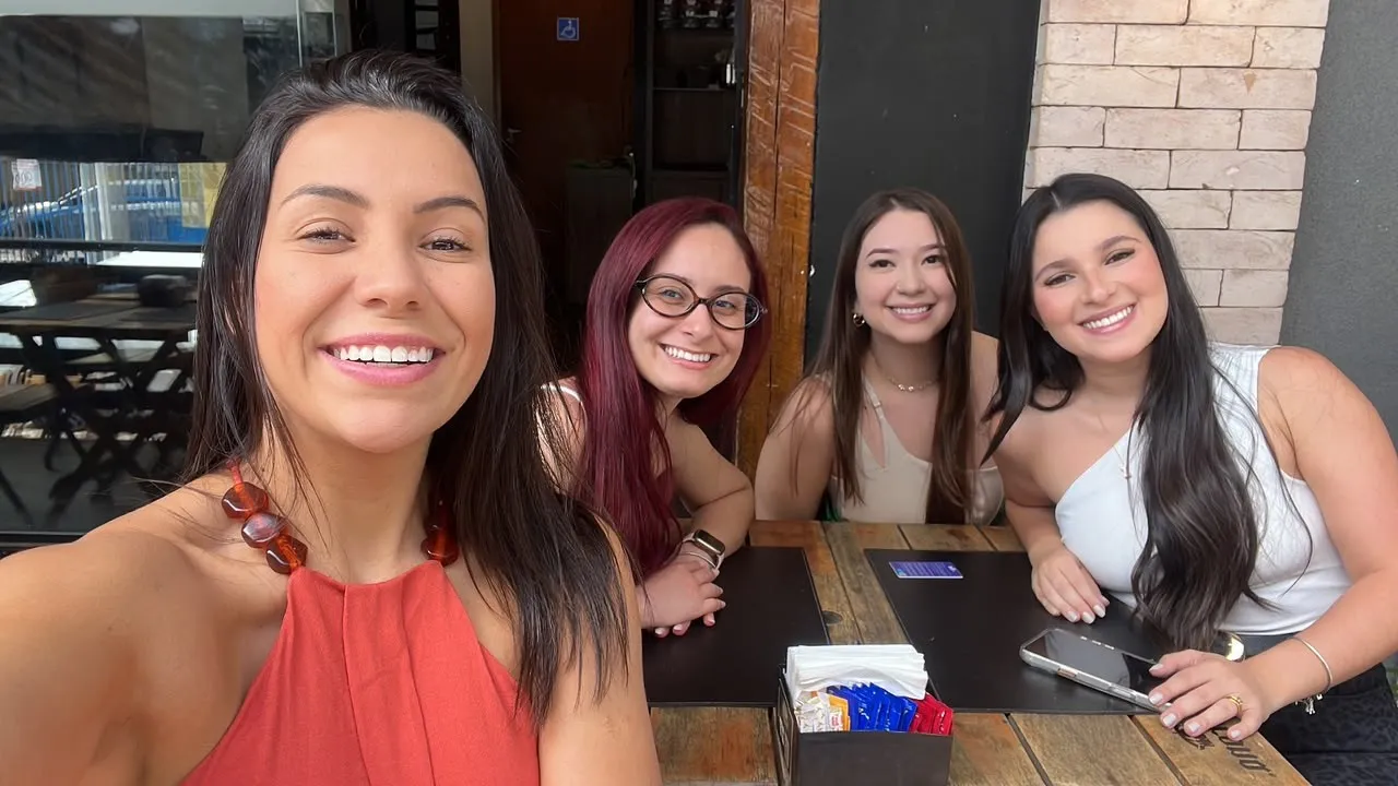 Teacher Gabriela tomando café com alunos durante uma viagem